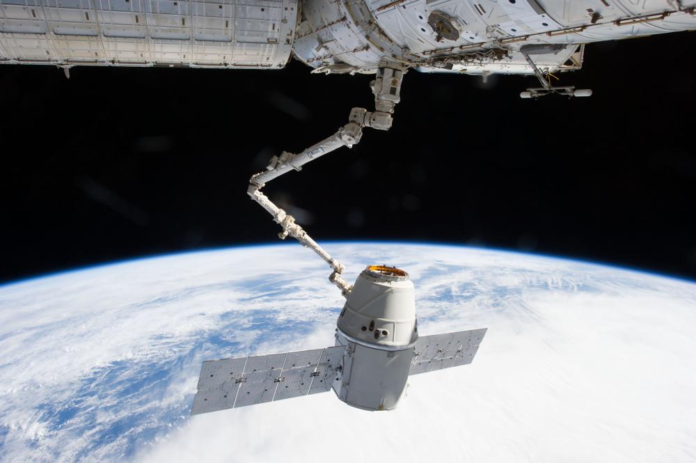 A spacecraft Dragon attached to the ISS with the mechanical arm made by a Canadian manufacturer. (www.universetoday.com)